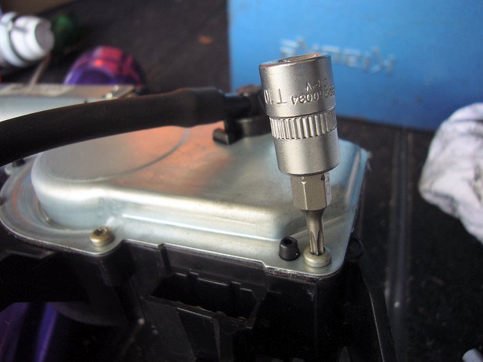 Die Schrauben der Abdeckplatte am Wischergetriebe entfernen