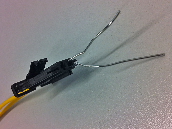 Die platten Enden in die zwei Spalten neben dem Stecker schieben und am Kabel ziehen